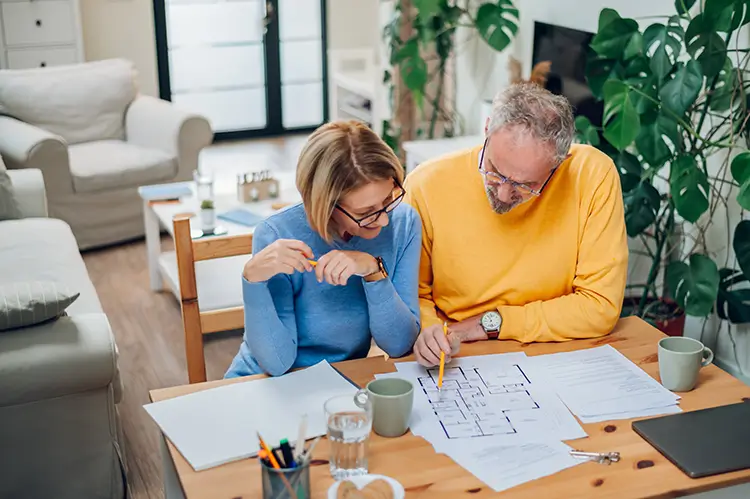 Senior couple looking over the blueprints of a house