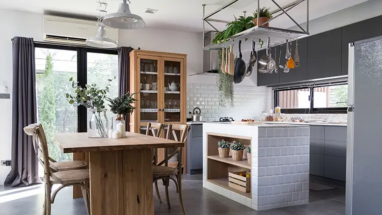 Cozy pantry kitchen area with natural wood dining table stainless hanging shelves in modern vintage style